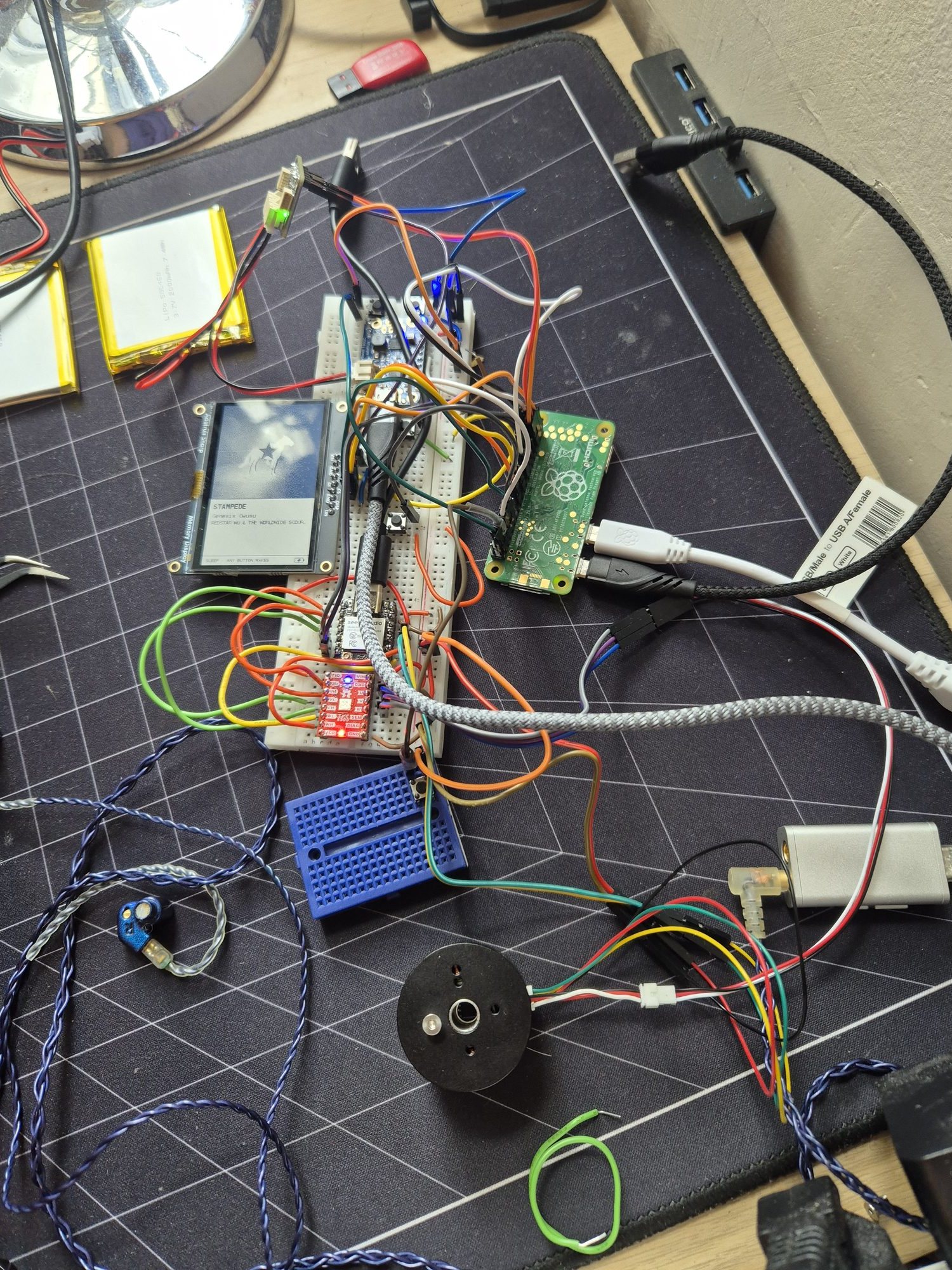 Breadboard prototype with a Pi Zero, Sharp memory display, XIAO, red TMC6300 driver board and the 2804 motor